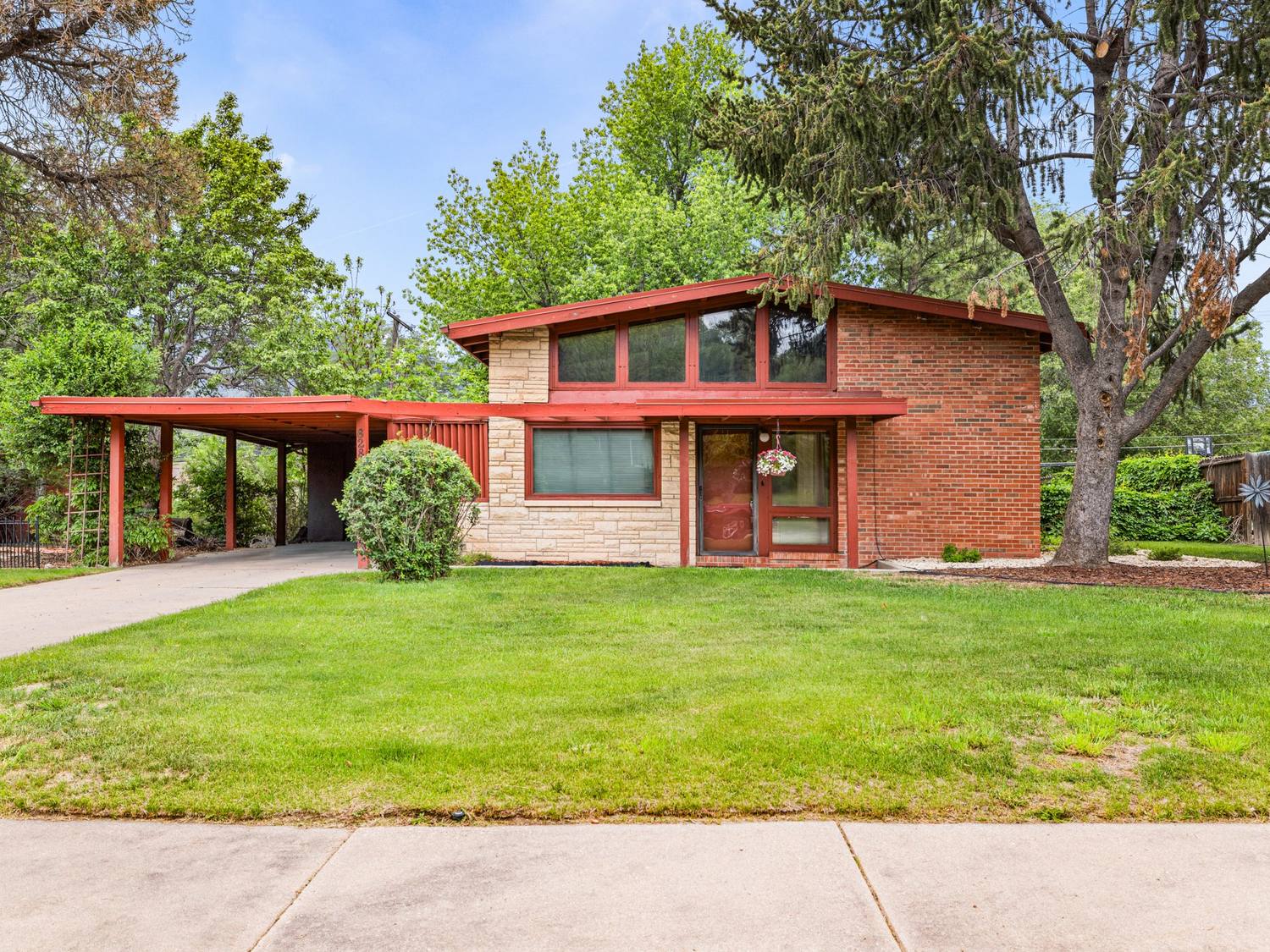 Mid-century modern home in Colorado Springs with red beams, brick and a carport