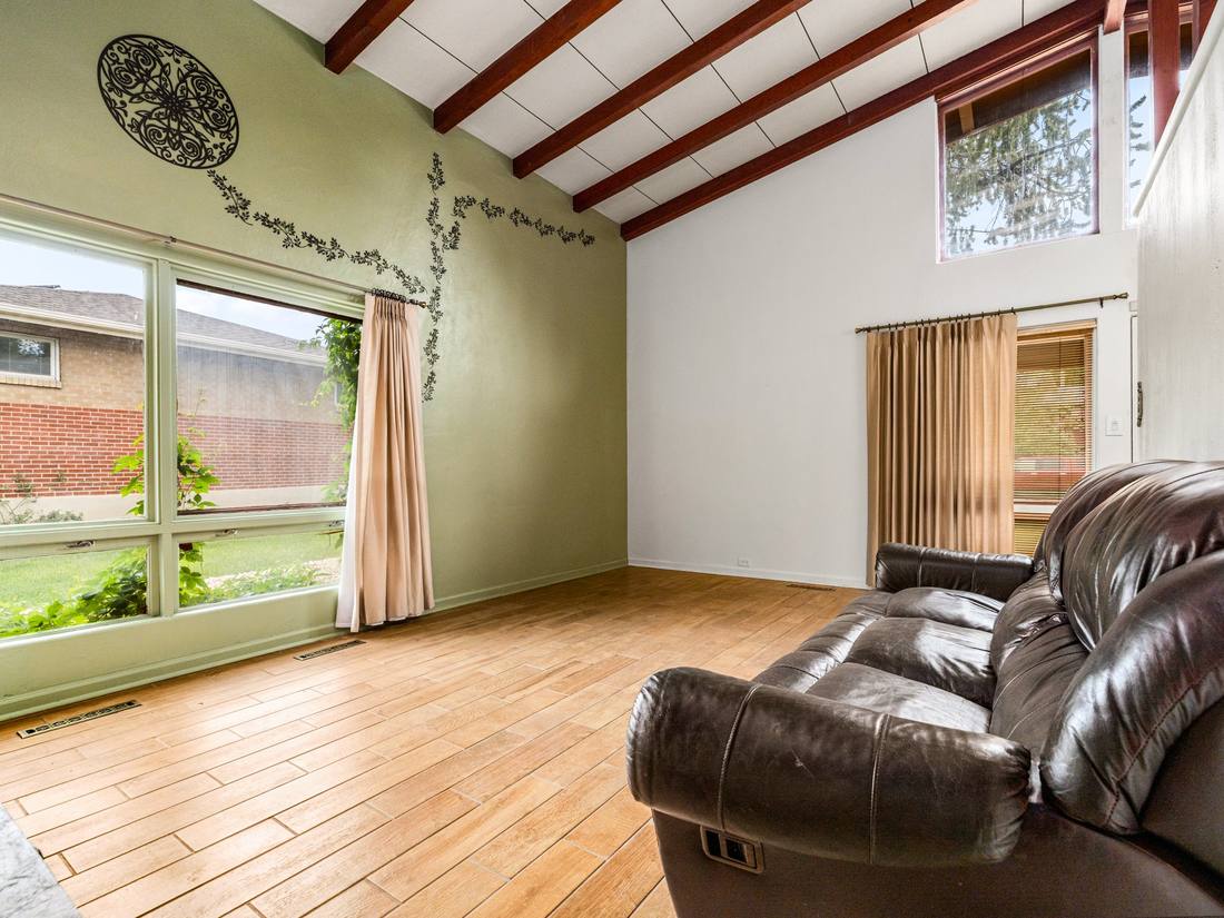 Sitting room with green walls and exposed beams