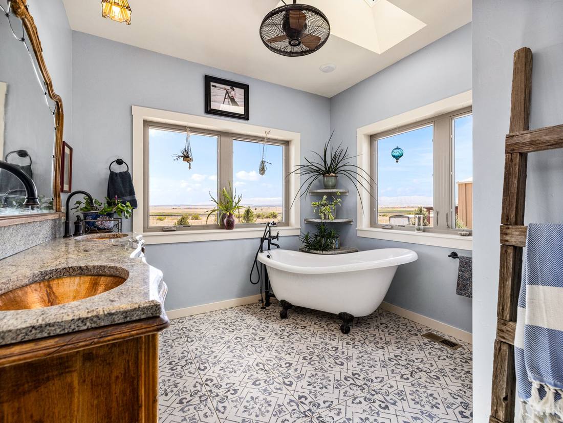 Clawfoot tub framed by windows over open country